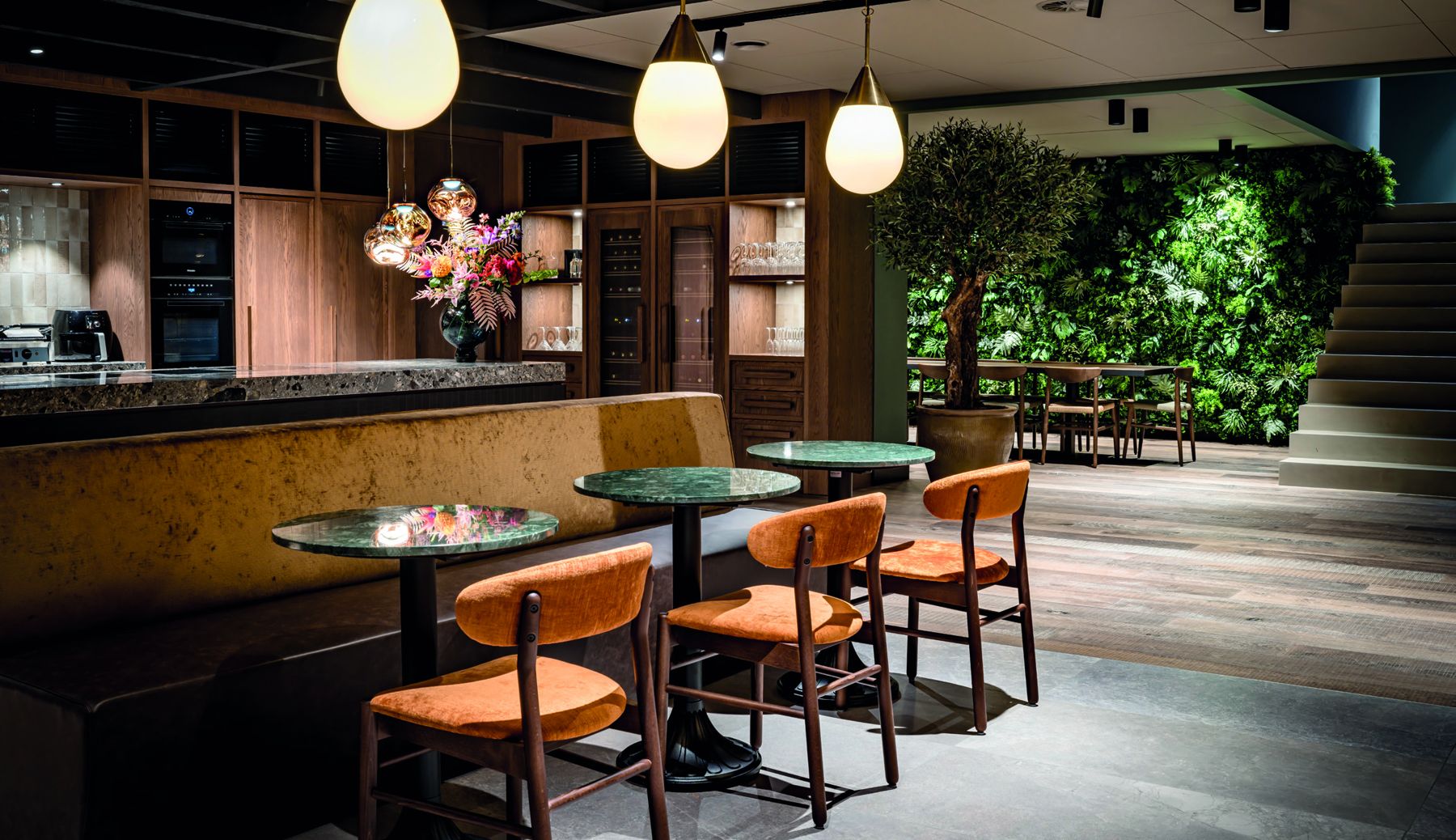 Het Eetcafé met marmeren tafels en een groene plantenwand
